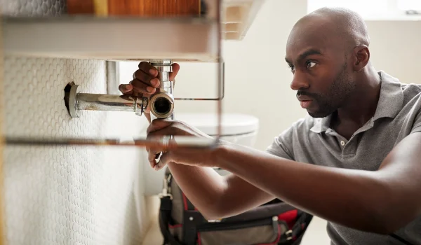a male plumber fixing a pipe connection from Emergency Plumber Richardson in Richardson, TX 